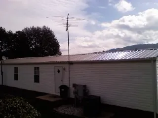 New metal roof on a single wide mobile home with a TV antenna in Bethlehem